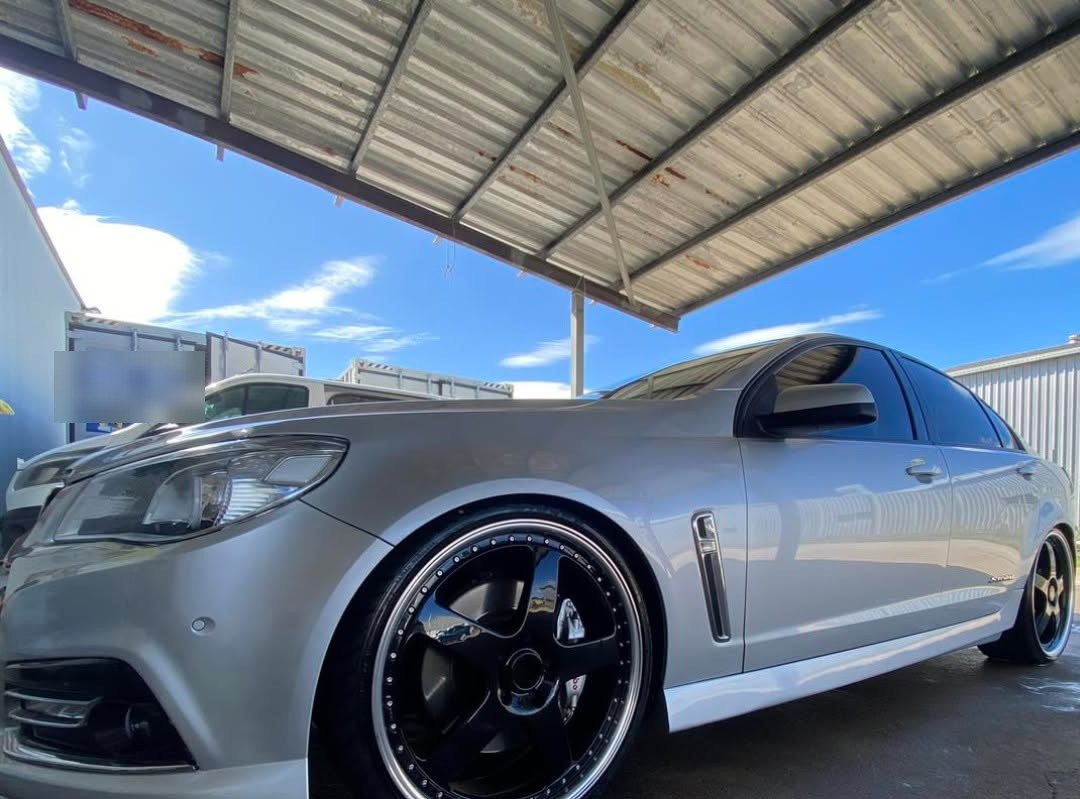 Silver sedan detailed under the workshop awning